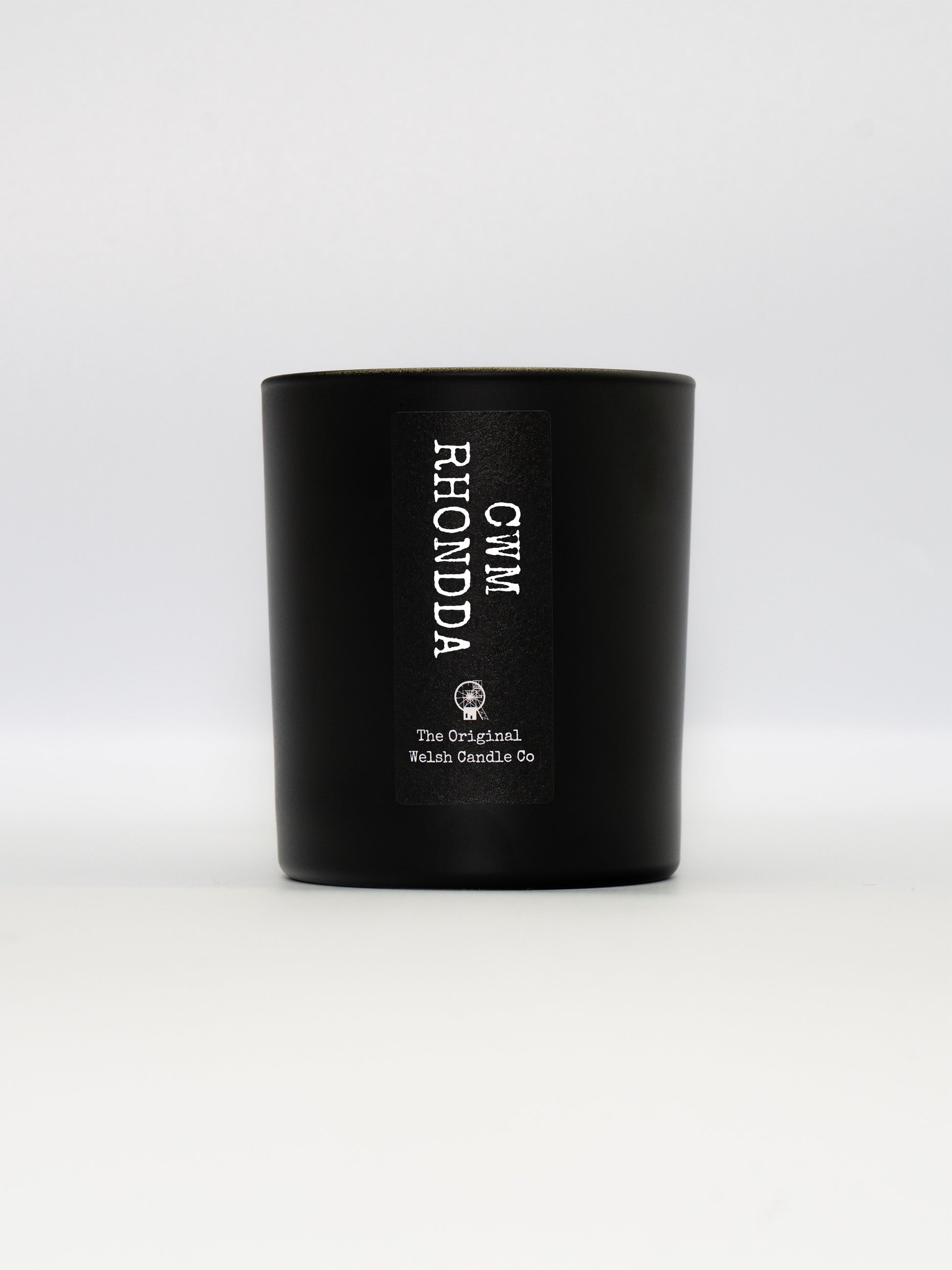 a matt black glass jar with a label saying CWM RHONDDA, filled with a luxury soy scented candle